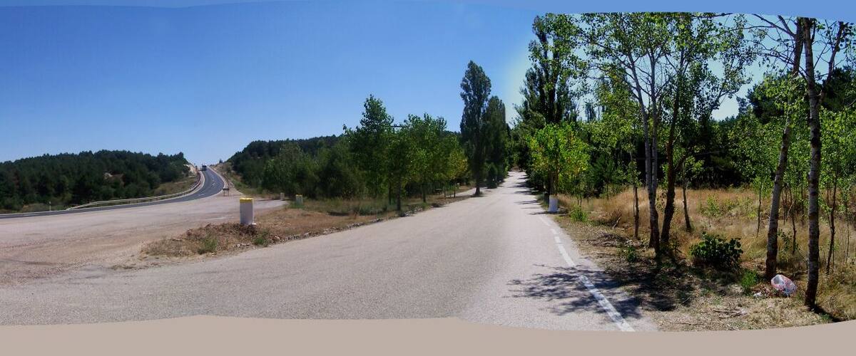 A winding road with a mountain in the background.