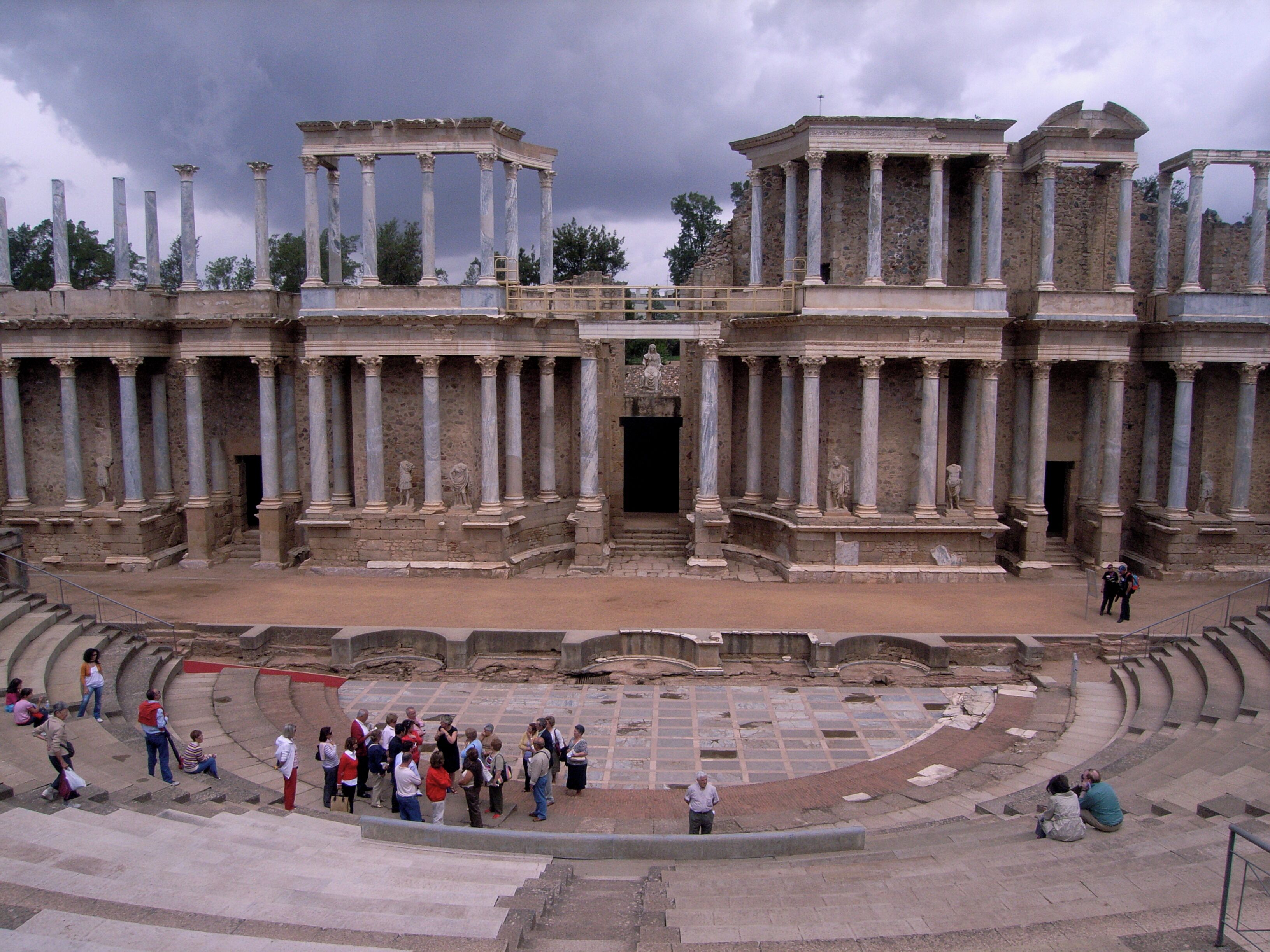 An ancient amphitheater with stone columns and a central stage.