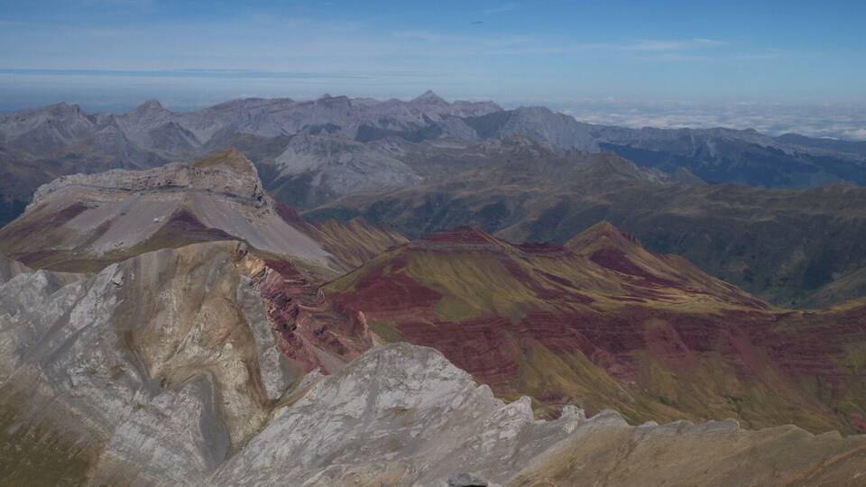 A mountain range with distinct red and yellow rock formations.