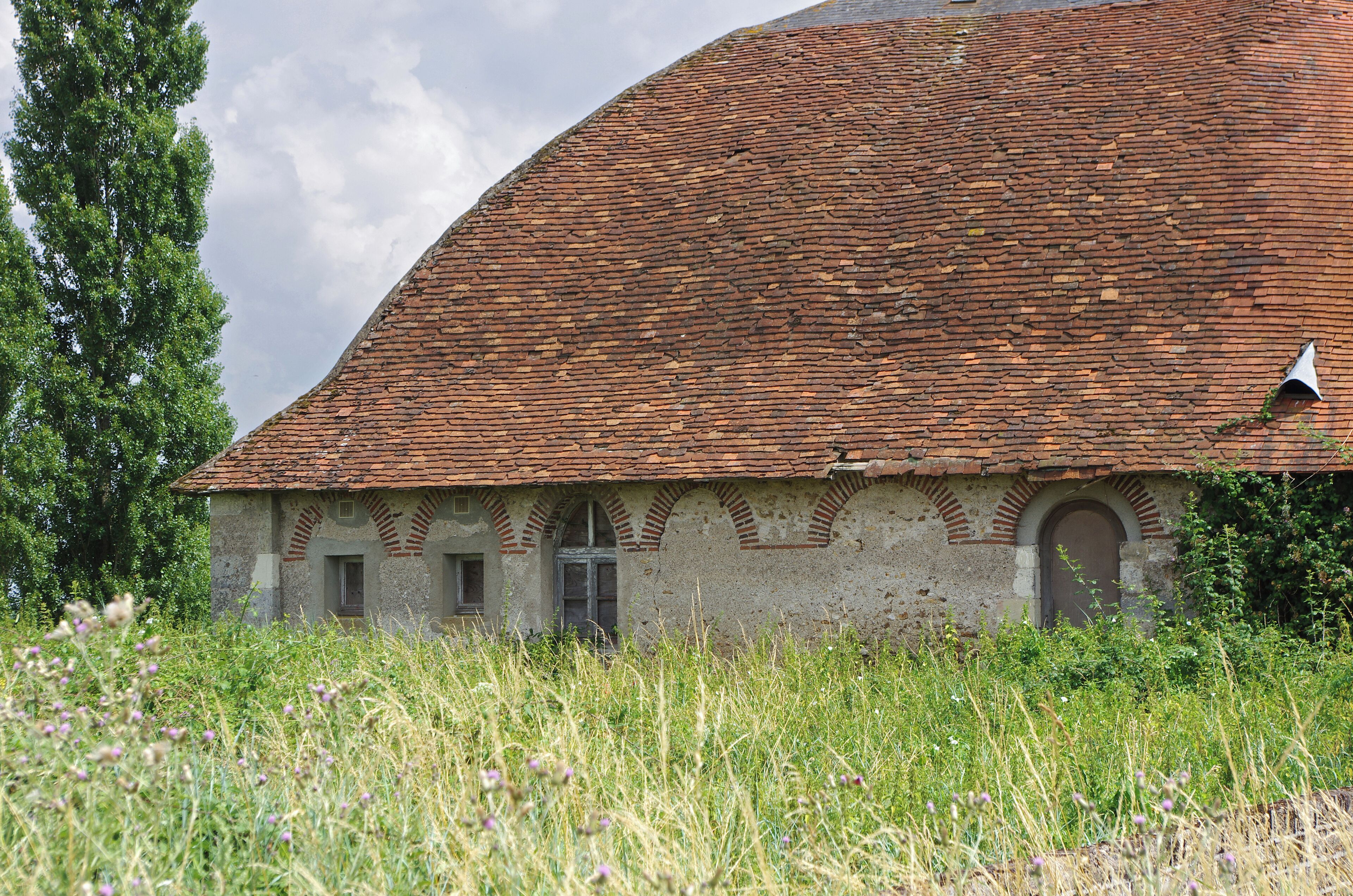 Mesland (Loir-et-Cher) Grange de la Perdrière. 47° 30' 33.6456" N 1° 7' 22.2384" E
 Cette grange semble dater du dernier quart du 18e siècle et du 1er quart du 19e siècle. Elle dépend du château de Monteaux et appartient à une société privée. Sa toiture particulière, semble sans équivalent dans le Loir-et-Cher. Les caractéristiques techniques de sa charpente permettent de dater la construction de la fin du 18e siècle. Les fermes sont constituées de 3 cours de planches formant un arc ogival rapprochées par des clous en fer forgé. Les fermes, sont les éléments de charpente qui supportent le poids de la toiture (triangulaires dans le cas de la charpente traditionnelle, mais ce n'est pas le cas ici). Le type de charpente est dit à la Philibert de l'Orme. Ce religieux du 16e siècle est surtout connu pour ses travaux d'architecture. En particulier, dans le livre X de son "Premier tome de l'architecture", Philibert de l'Orme décrit un nouveau type de charpente pouvant utiliser du bois court pour des toitures à grand développement. Ce type de charpente est cher en main d'oeuvre, économe en bois et généreux en espace. Une toiture à la Philibert de l'Orme ressemble à une carène de navire renversée. This barn appears to date from the last quarter of the 18th century and the first quarter of the 19th century. The type of timber work is said to Philibert de l'Orme. It is a timber work frame-shaped hull ship