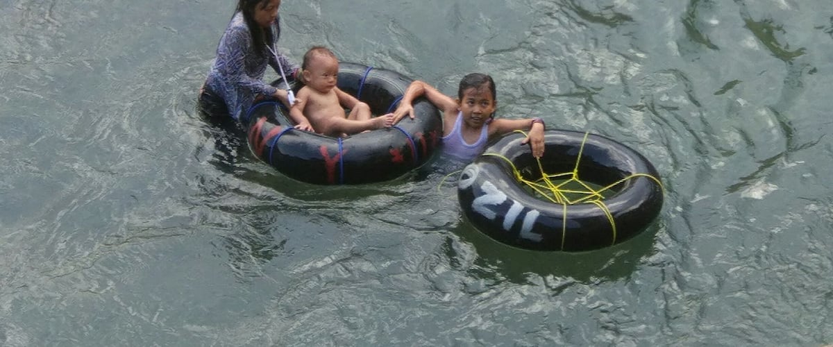 Two people in a tube on a body of water.