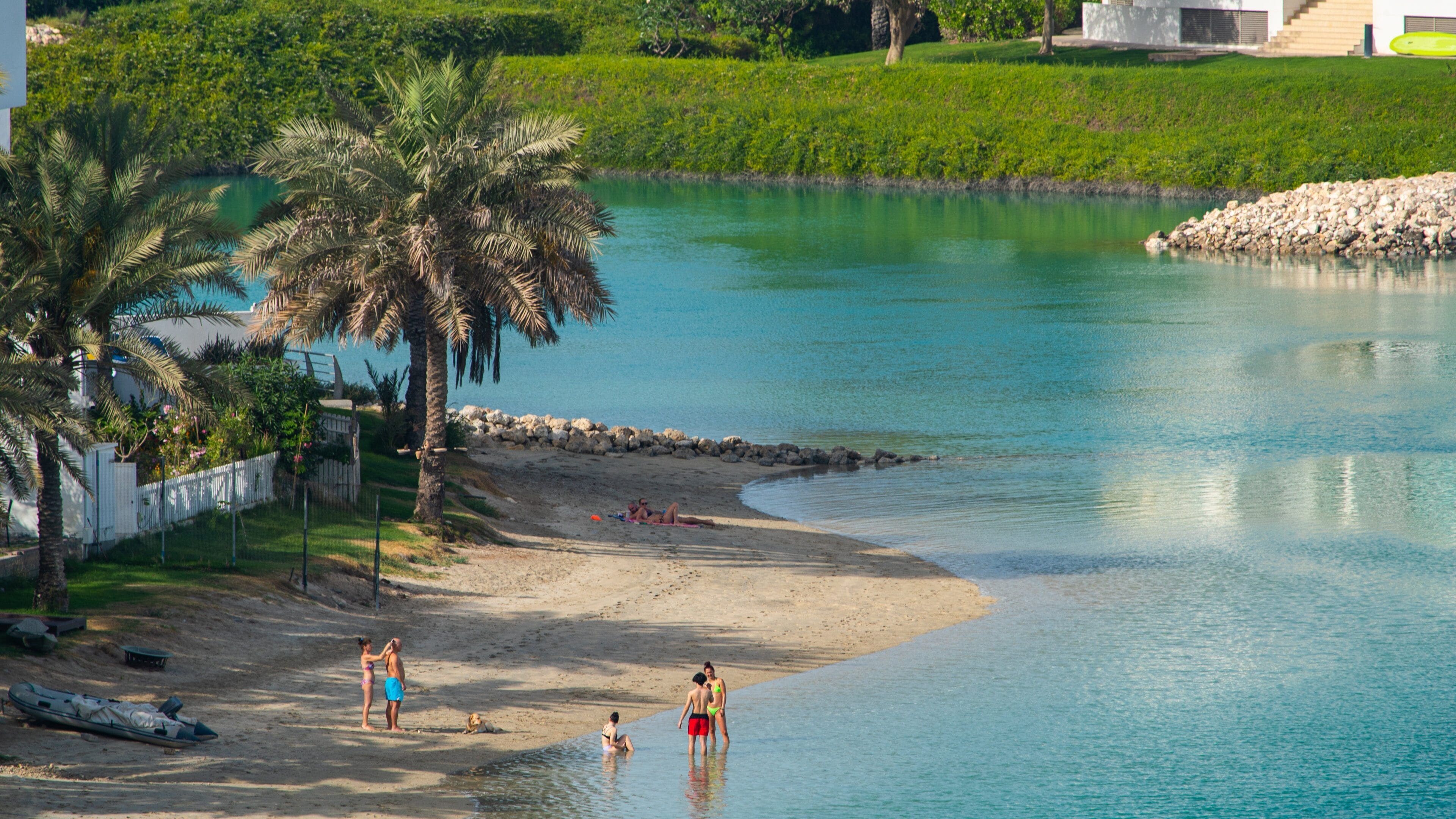 Amwaj Islands showing a sandy beach and a river or creek as well as a small group of people