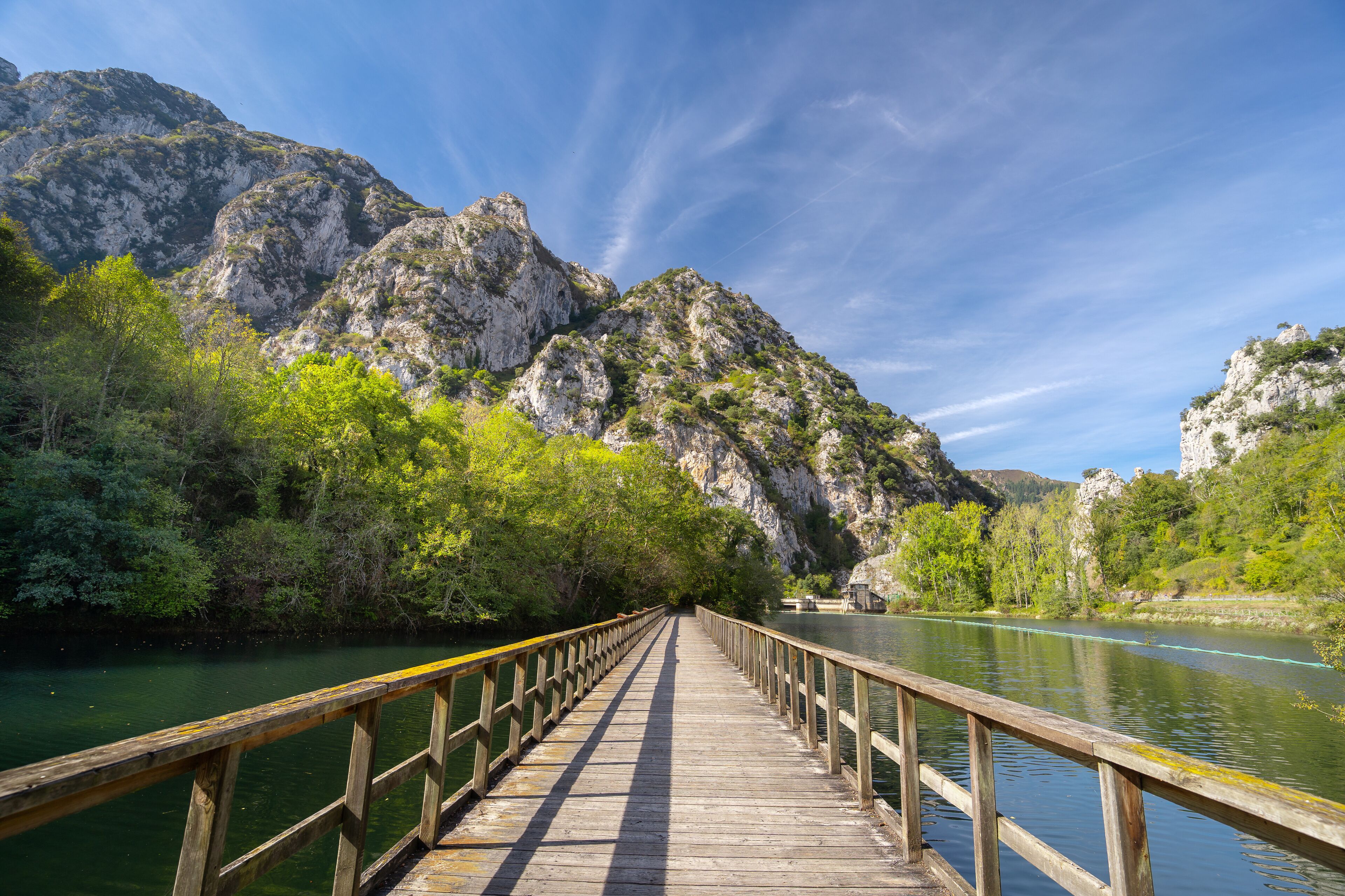 Wooden bridge over the Valdemurio reservoir in autumn. Bear Trail. Quirós, Asturias, Spain