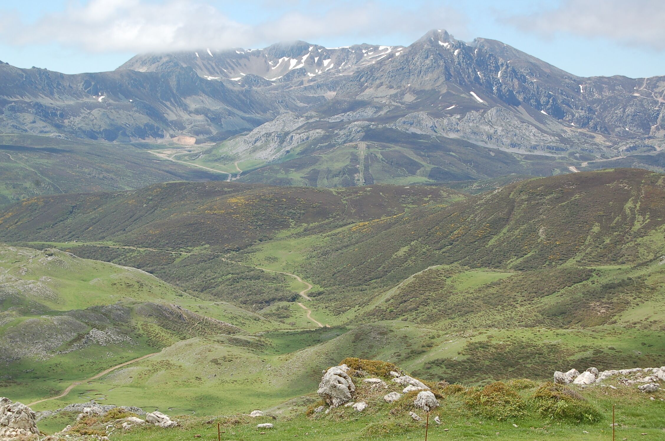 A mountainous landscape with green valleys and rocky outcrops.