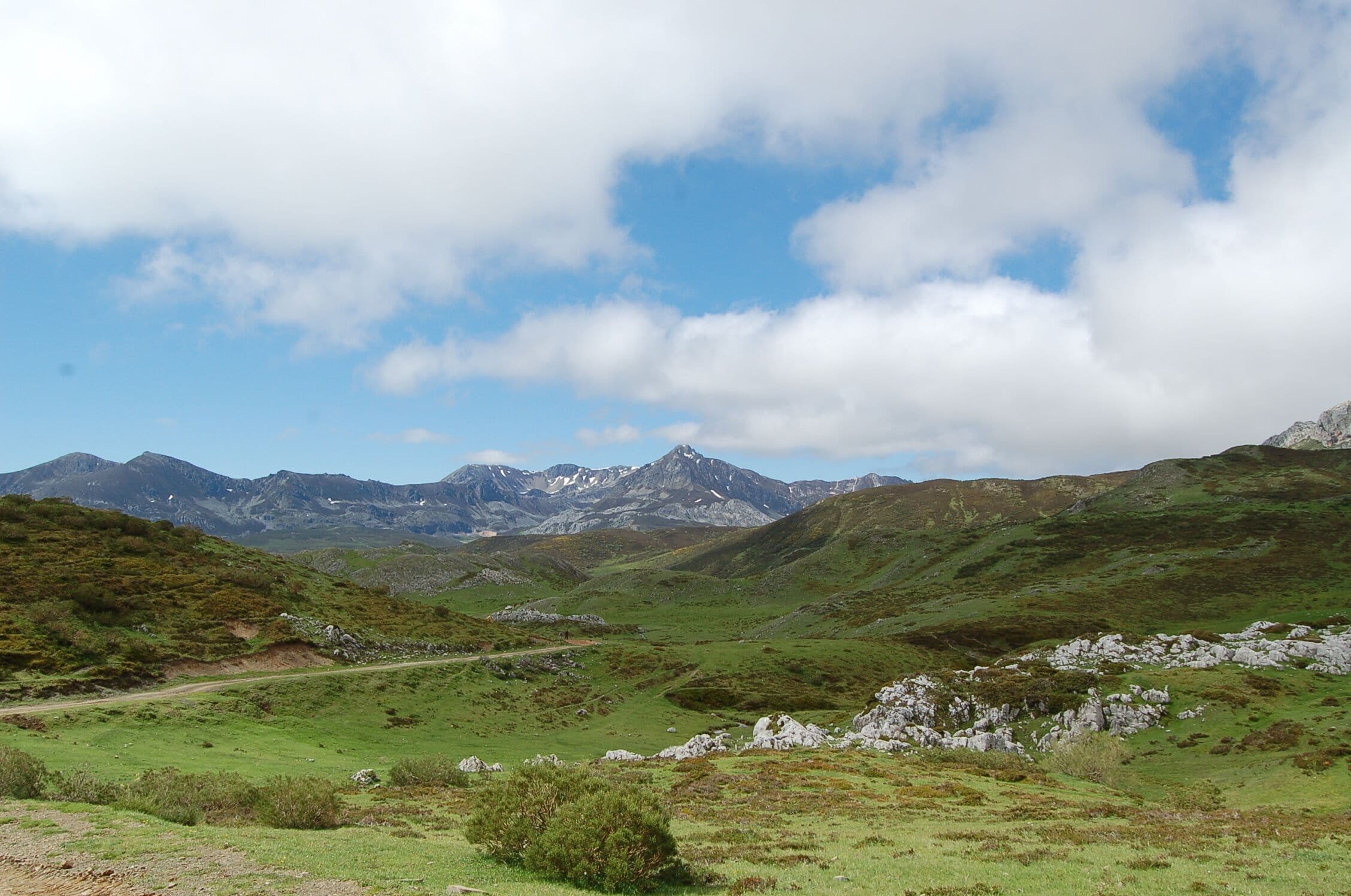 A mountainous landscape with green valleys and rocky outcrops.