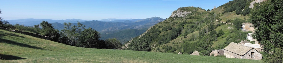 Eine Berglandschaft mit einem Steinhäuschen an einem Hang.