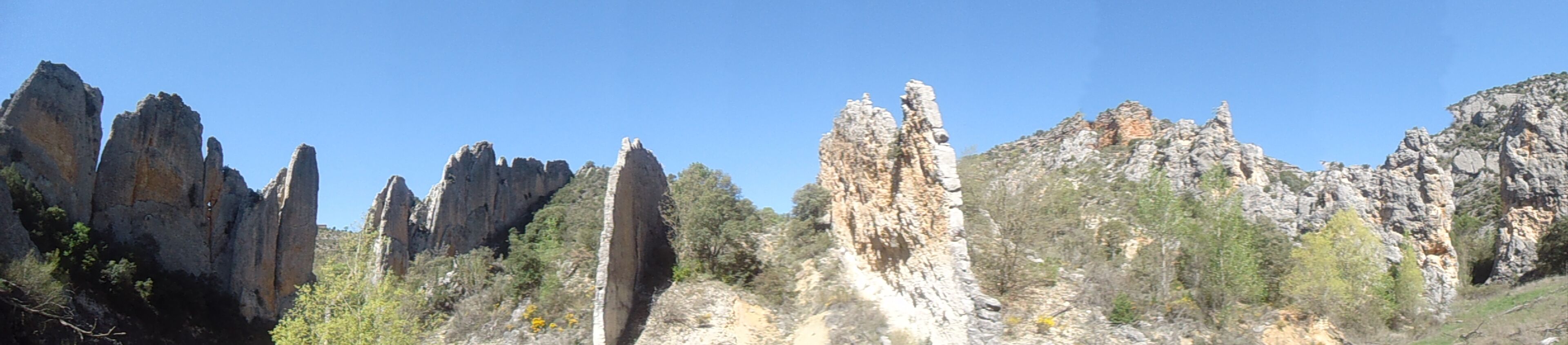 A rocky landscape with prominent limestone formations and sparse vegetation.