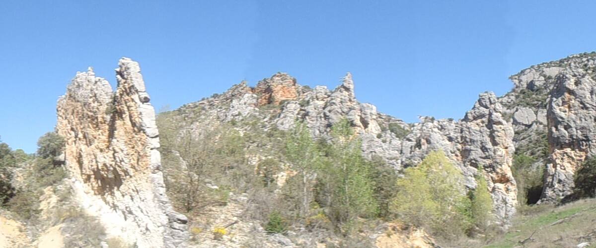 A rocky landscape with prominent limestone formations and sparse vegetation.
