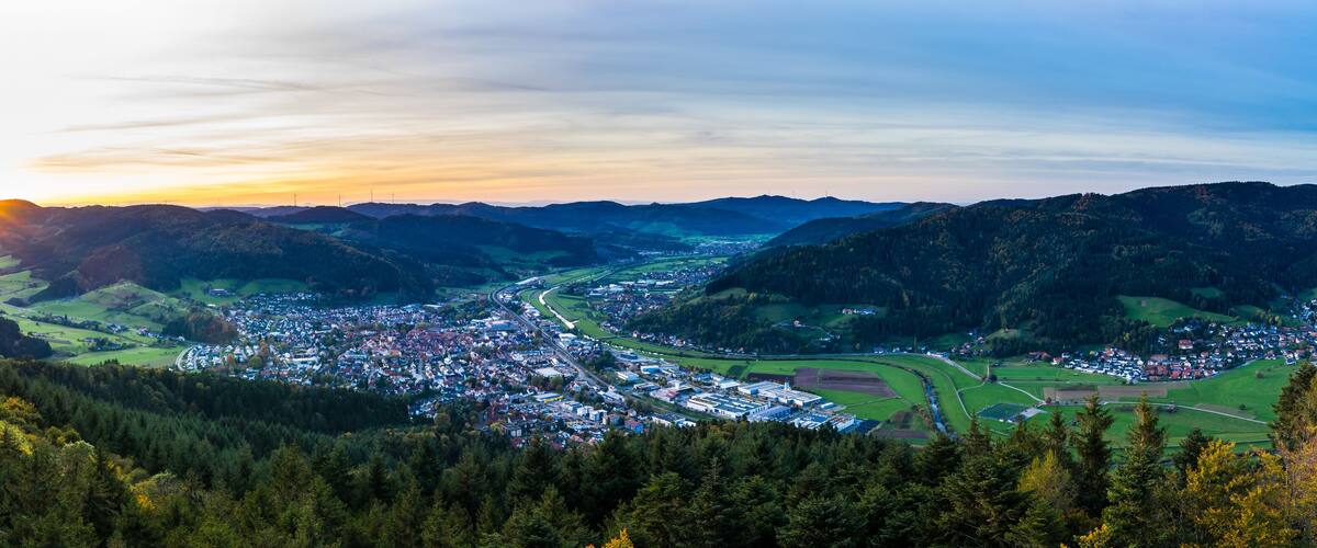 A valley town surrounded by mountains, with a river running through it.