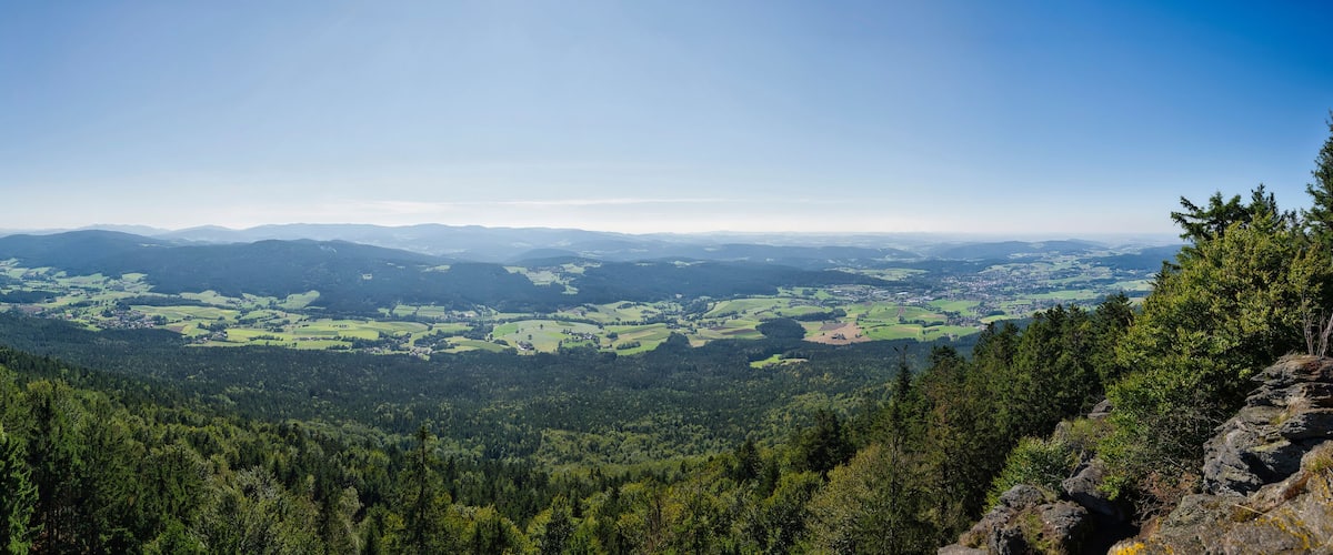 A mountainous landscape with dense forests and rolling hills.