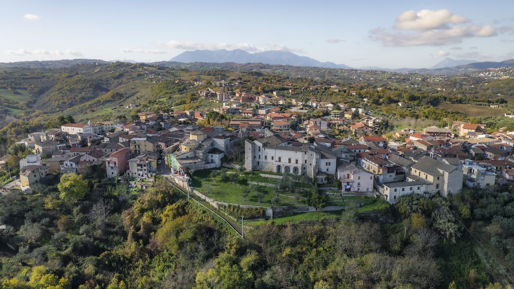 A mountainous town with dense greenery and historic buildings.