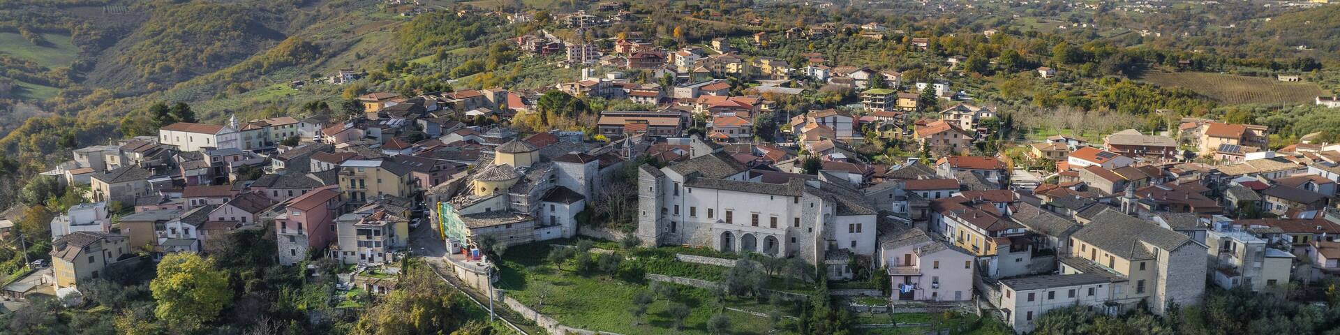 Aerial view of the ancient Castello Filangieri standing proudly amidst lush greenery, with the town cascading down the hillside, Lapio, Irpinia, Campania, Italy.
