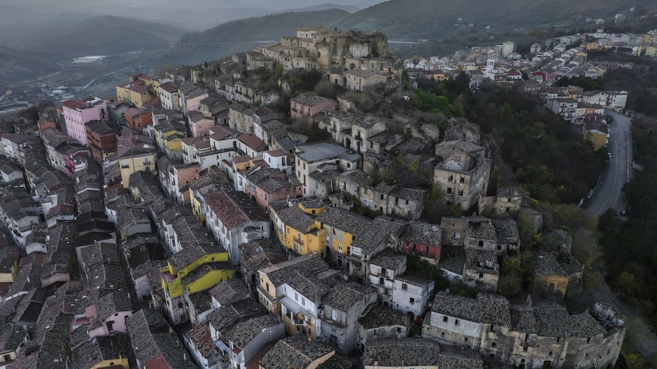 A historic town with colorful buildings and a prominent castle on a hill.