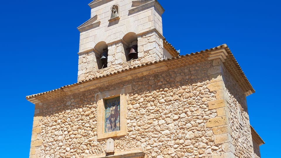 A stone church with a bell tower and a wooden door.