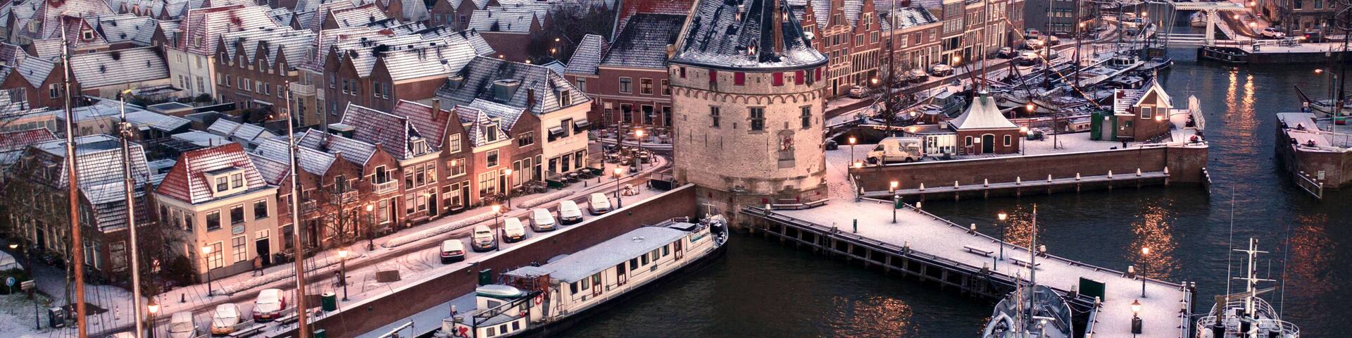 A snow-covered waterfront with historic buildings and a prominent tower.