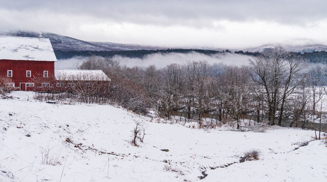 farm with red barn overlooking river in rural Vermont, New England