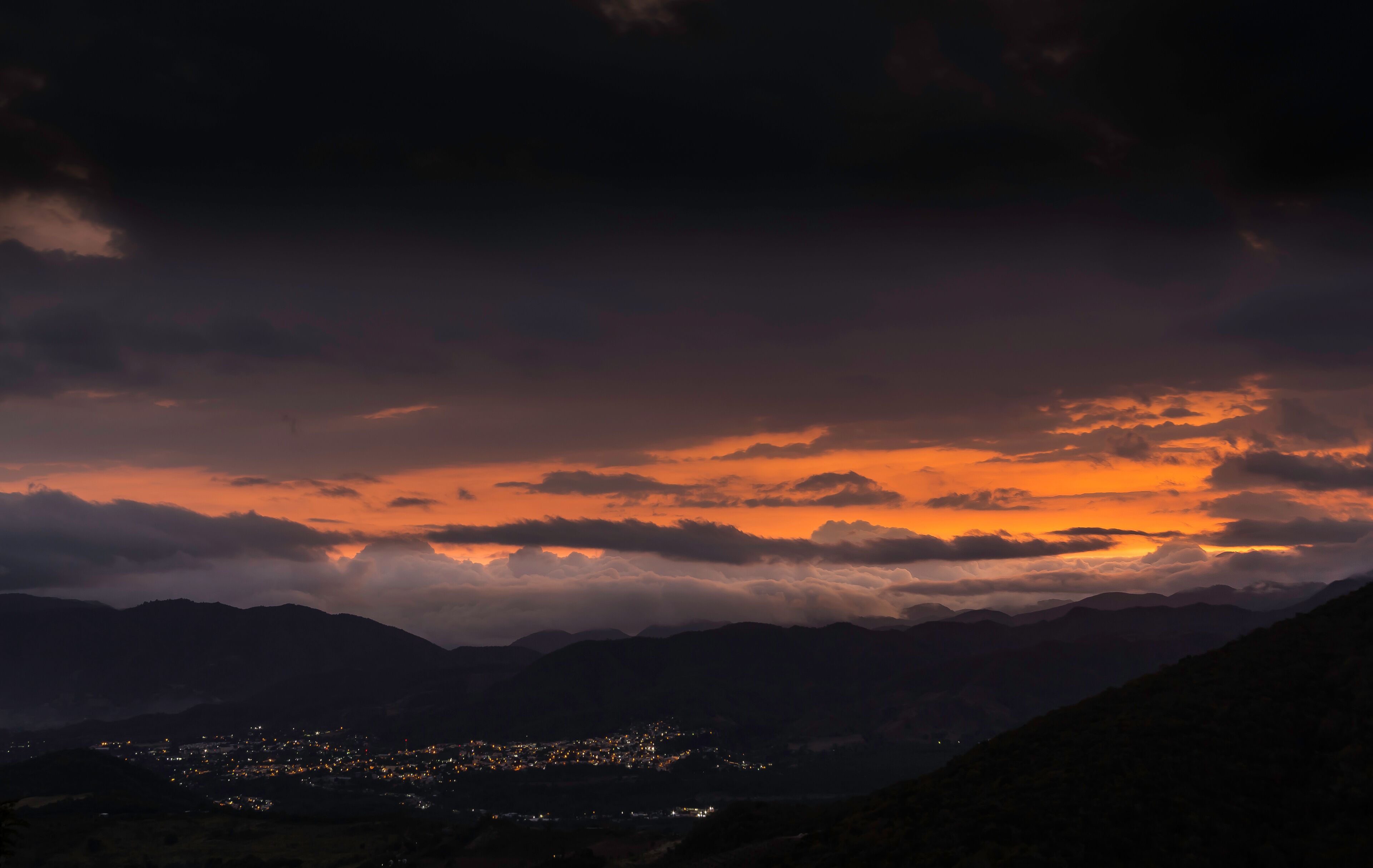 dramatic orange sunset landscape over the mountain town of San Jose De Ocoa, dominican republic.