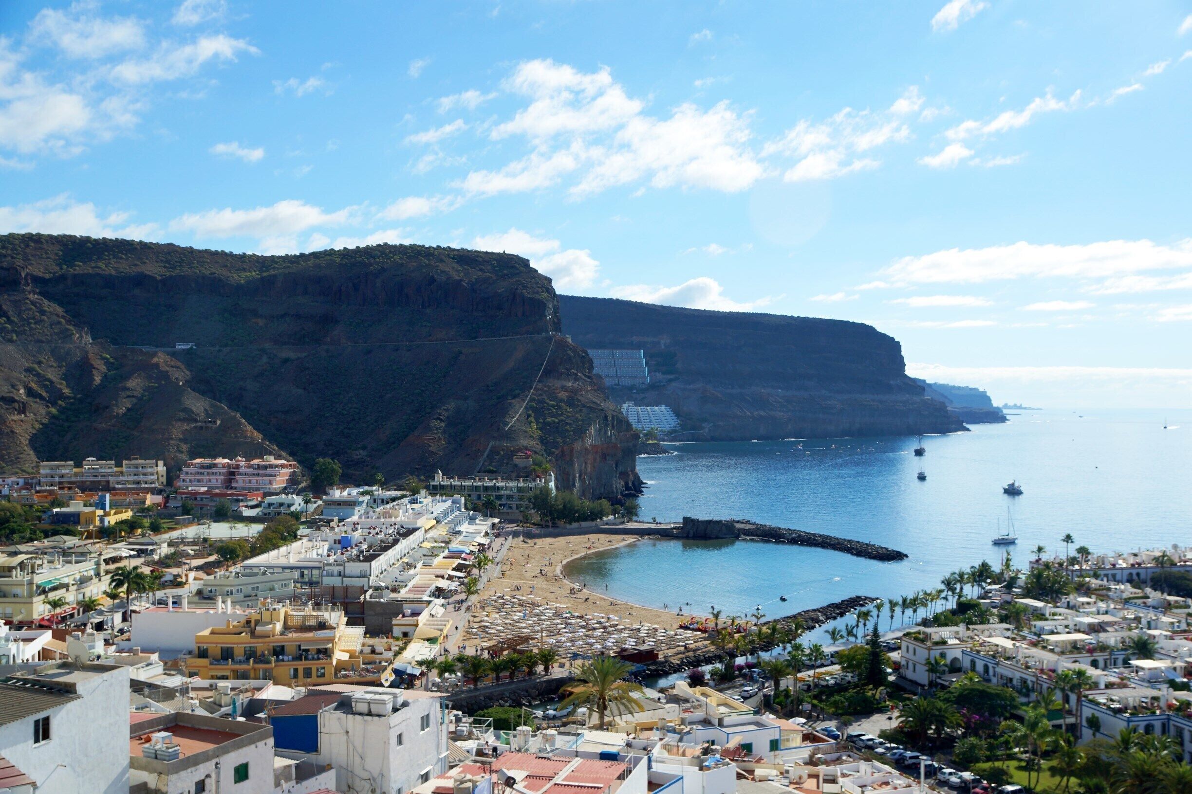 A coastal town with a beach, cliffs, and a harbor.