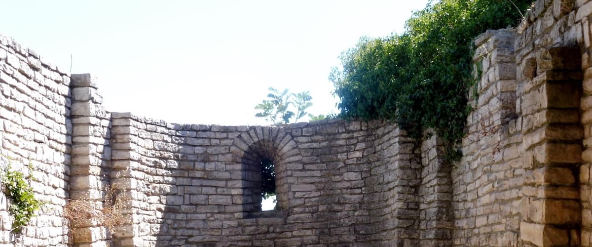 An ancient stone structure with a central arched window and a small platform.