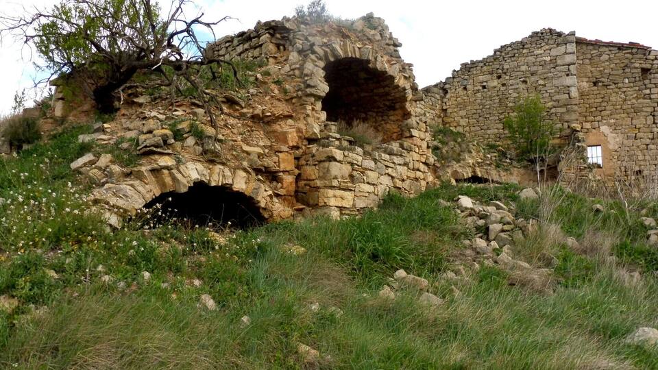 A stone ruin with an arched entrance and a partially intact building.