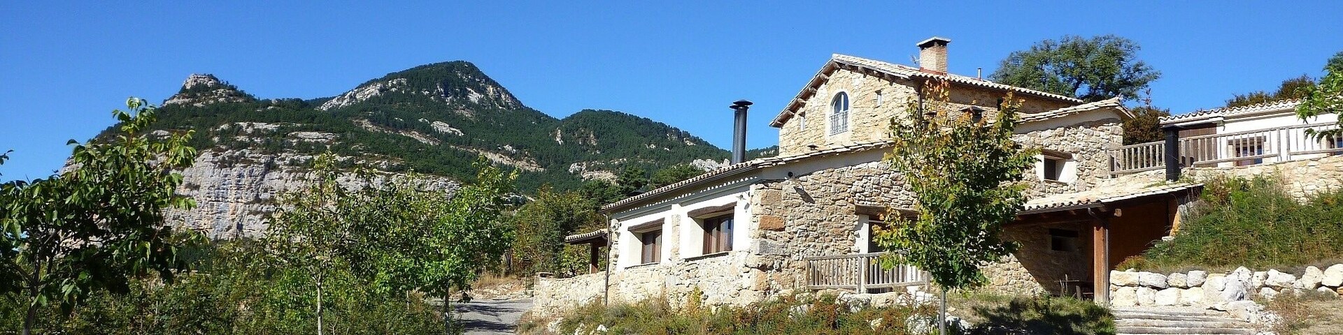 Cal Pubilló s'ha convertit en Casa de Turisme Rural. Al fons, la Roca de Canalda