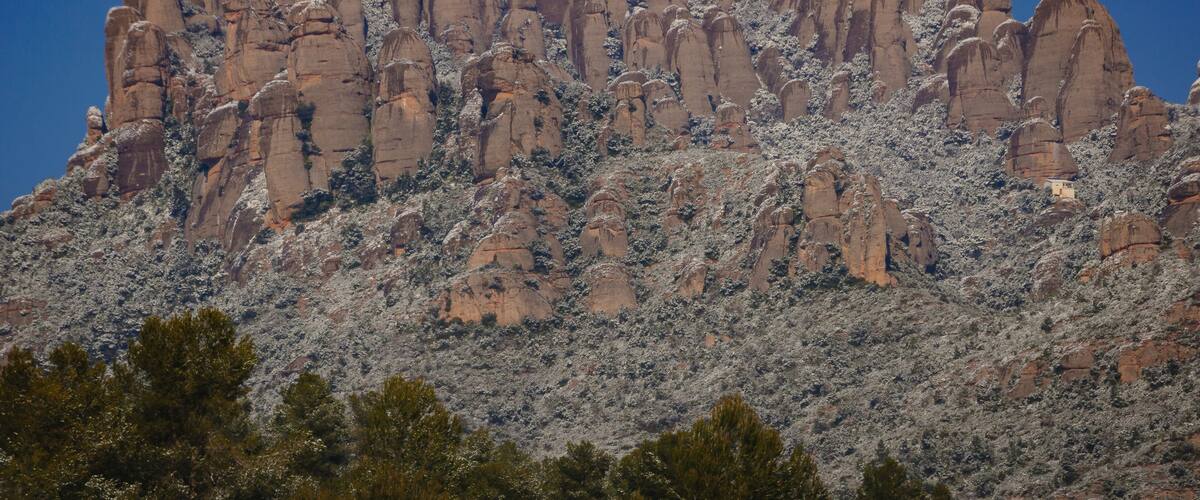 A rugged mountain range with prominent rock formations and sparse vegetation.