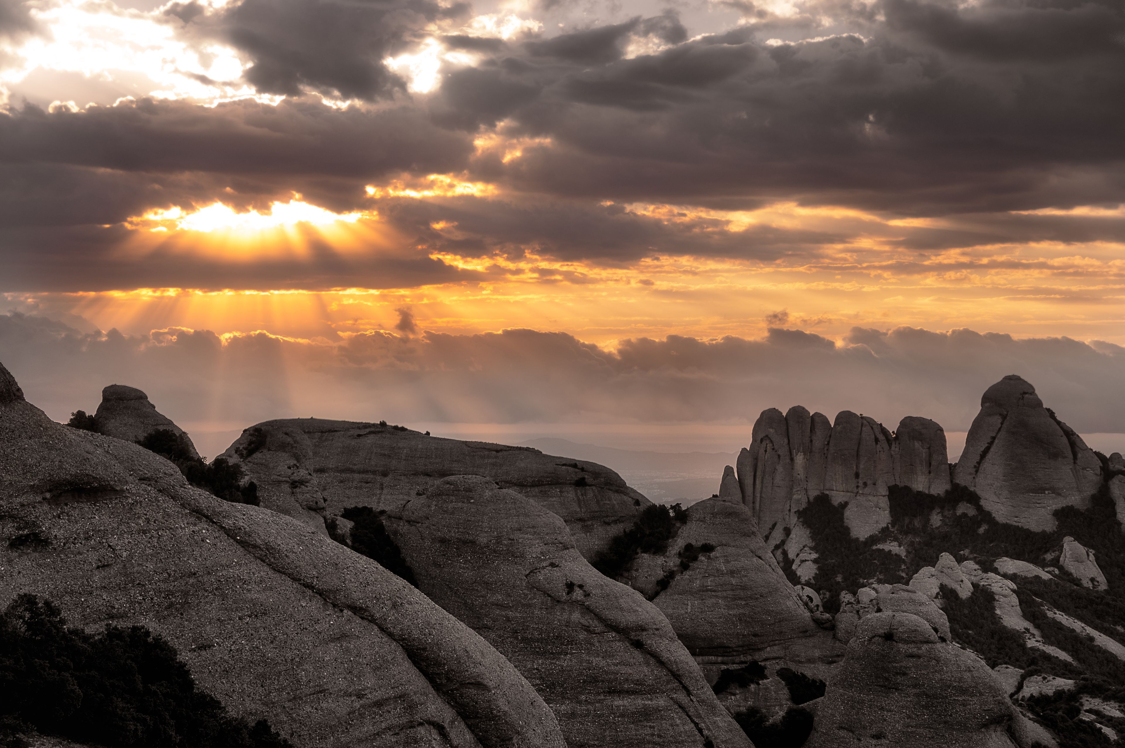 A rugged landscape with prominent rock formations and a dramatic sunset.