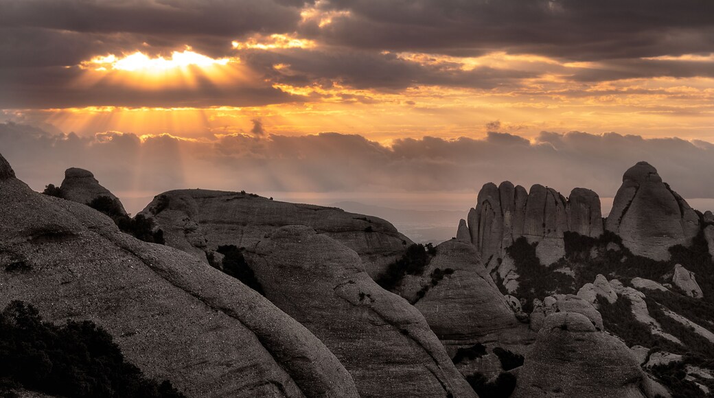 A rugged landscape with prominent rock formations and a dramatic sunset.
