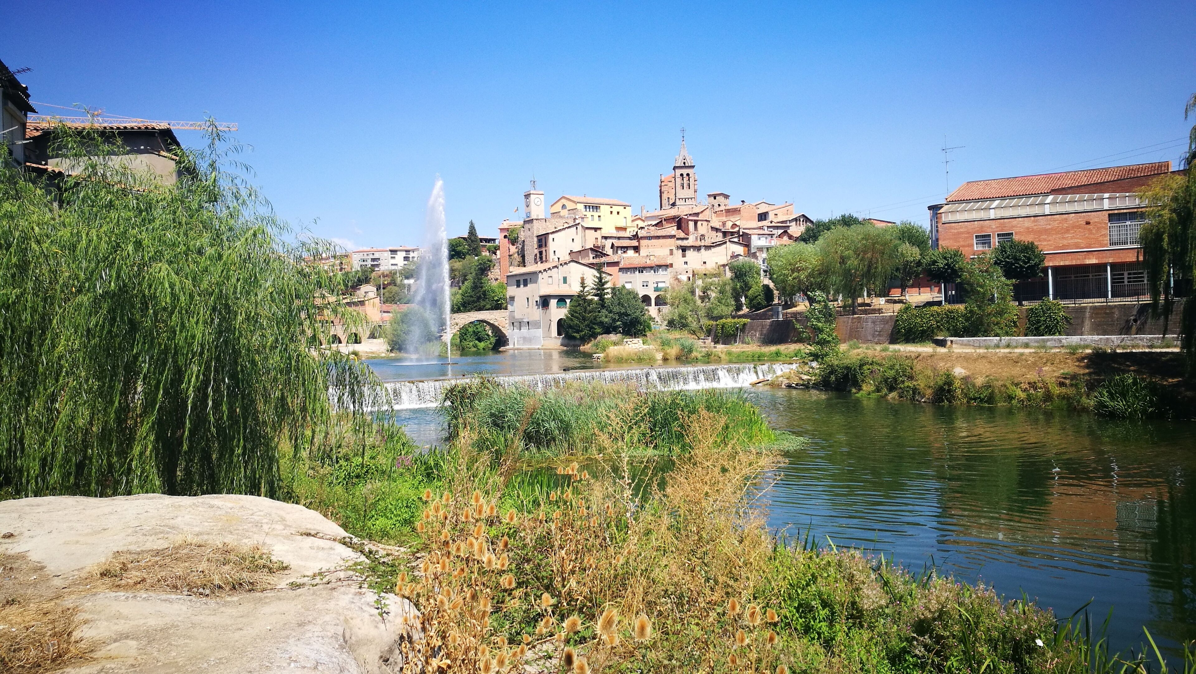 A town with a river, a fountain, and historic buildings.
