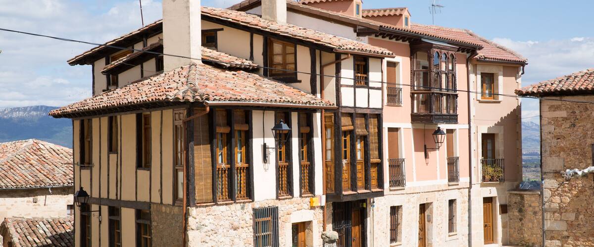 A traditional European building with a tiled roof, wooden balconies, and stone walls.