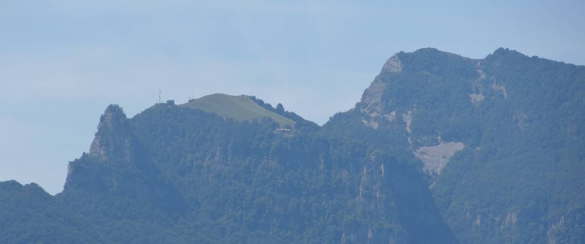 A mountain range with a prominent peak and dense forest.