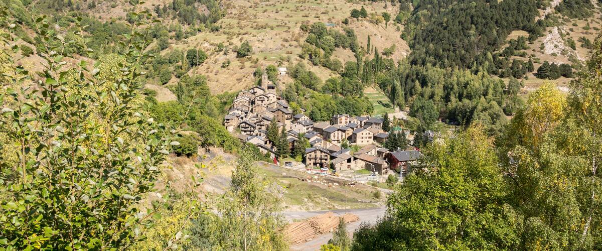 A village nestled in a valley surrounded by hills and forests.