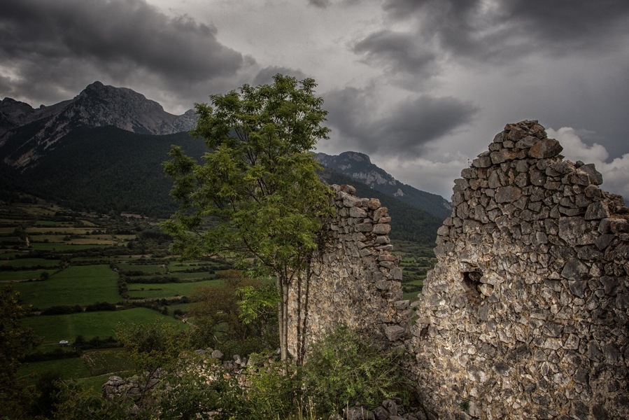 Castle ruins above Gósol, Spain. Outdoor sports attractions abound. The Pedraforca towers over the community in the background, a huge monolith and summit destination