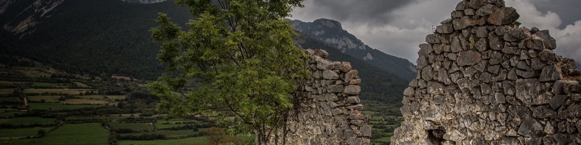 Castle ruins above Gósol, Spain. Outdoor sports attractions abound. The Pedraforca towers over the community in the background, a huge monolith and summit destination