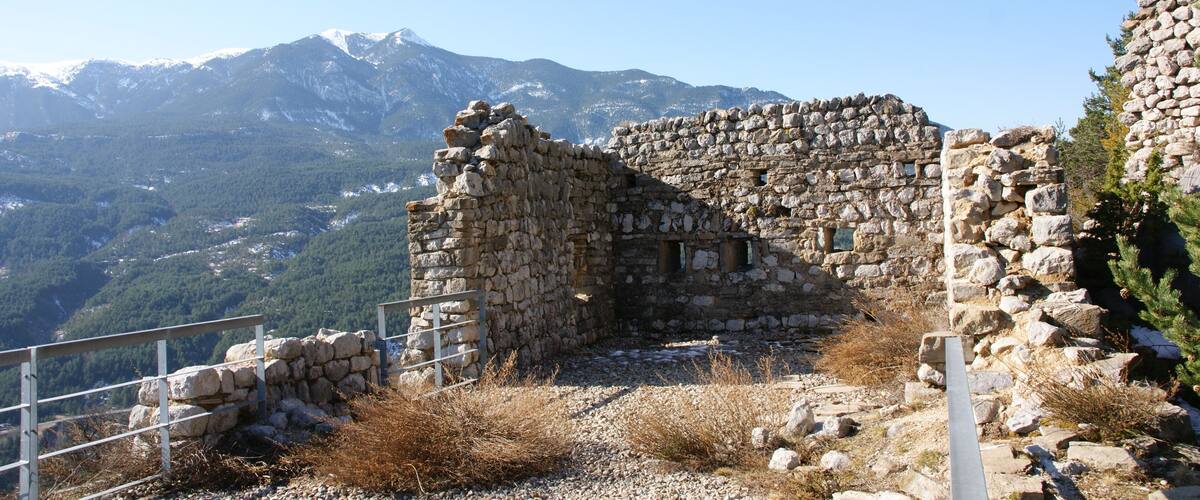A stone ruin with a mountain backdrop.