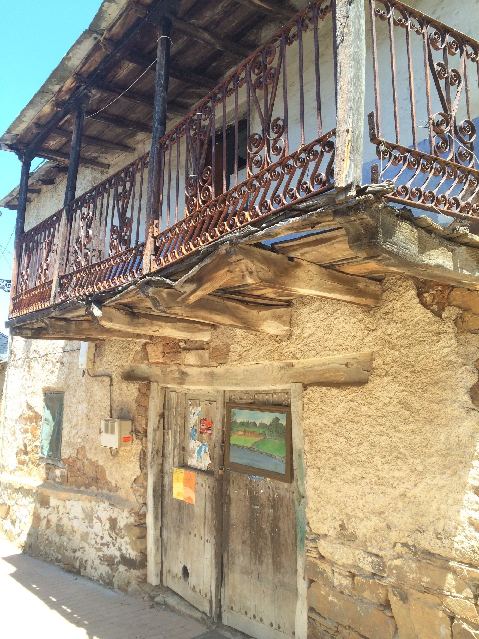 A rustic building with a wooden balcony and a weathered facade.