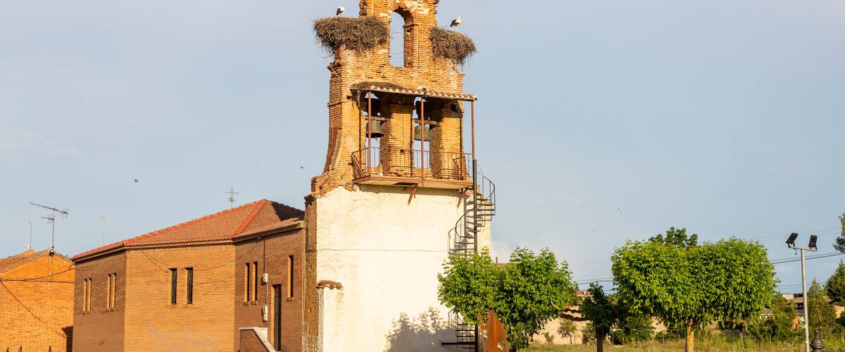 A historic church with a bell tower, a cross at the top, and a small bell.