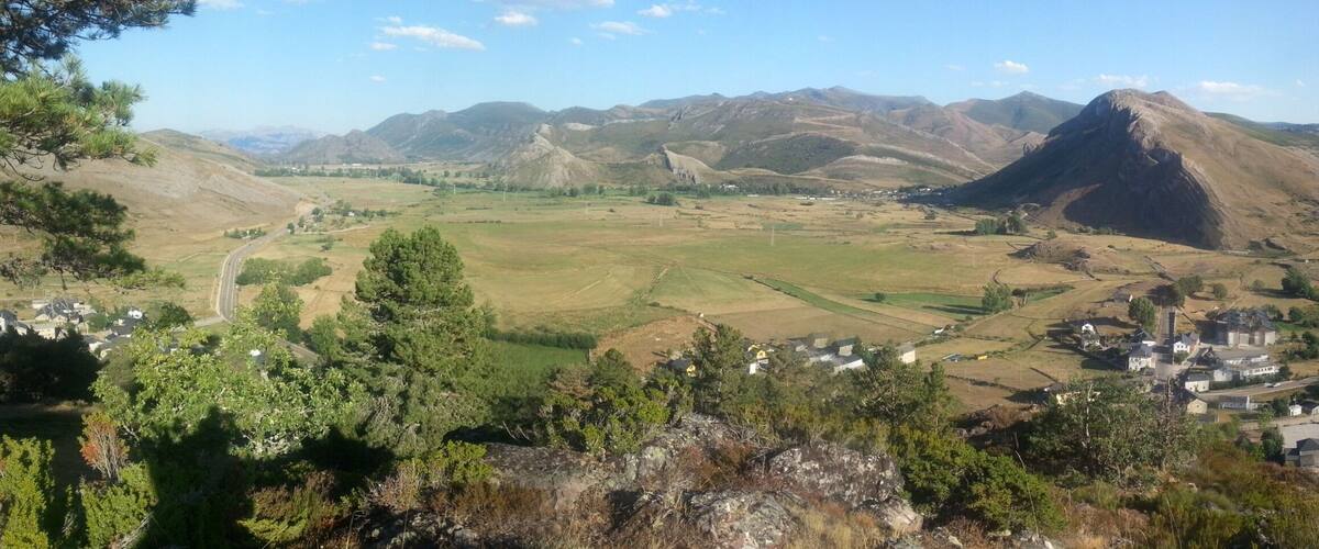 A mountainous landscape with a village nestled in a valley.