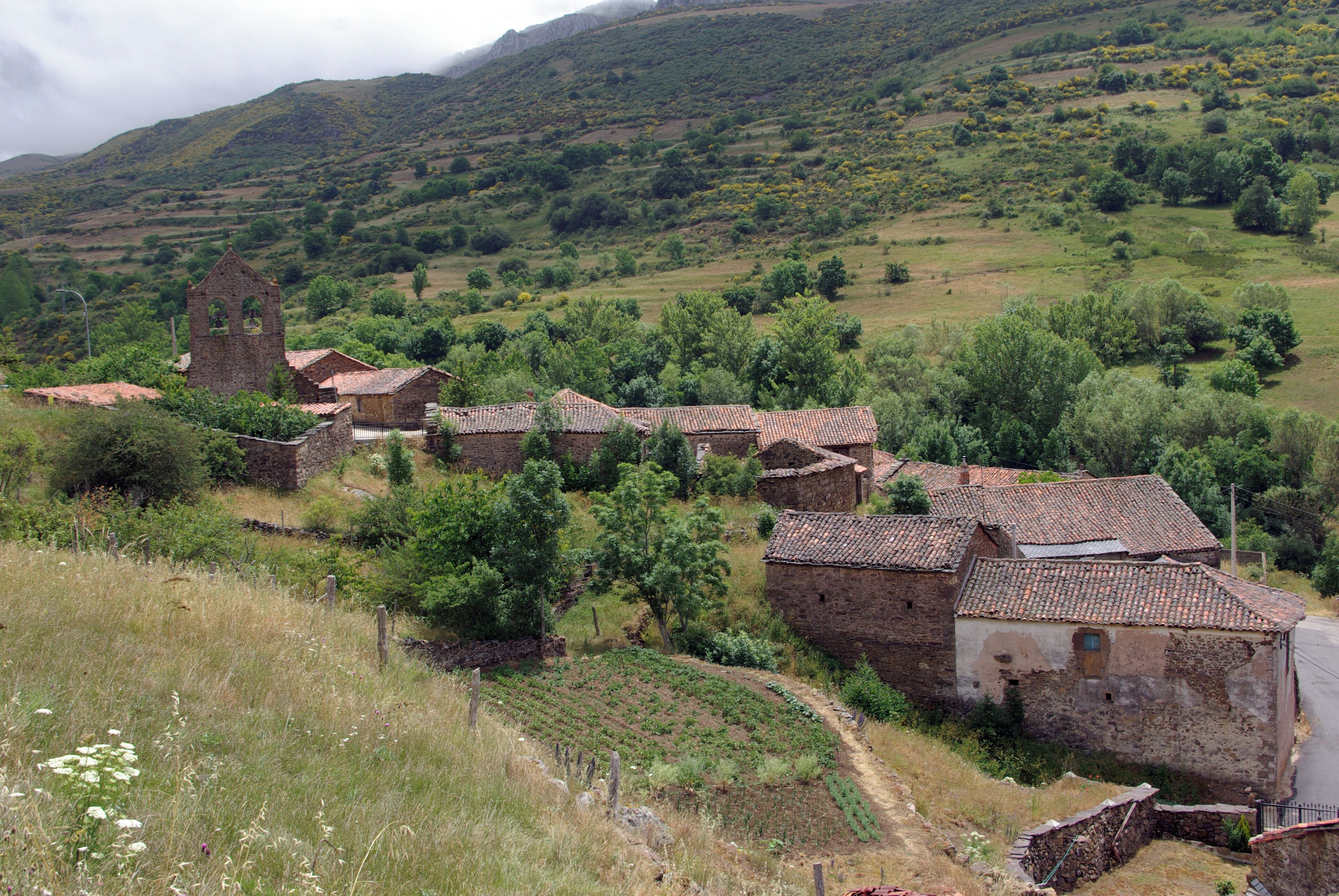 A rural village with traditional stone houses and a church tower.