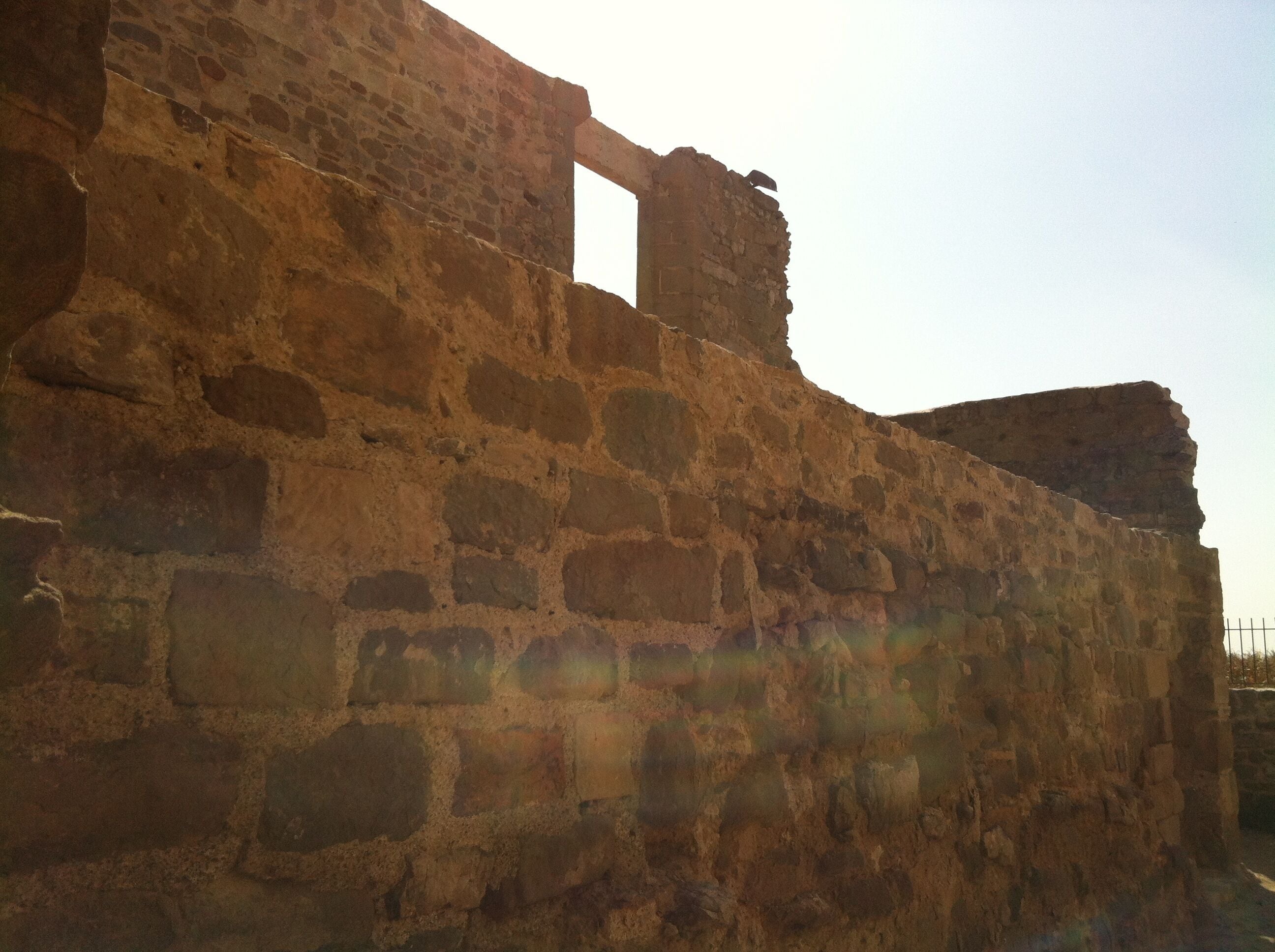 An ancient stone wall with a partially intact archway.