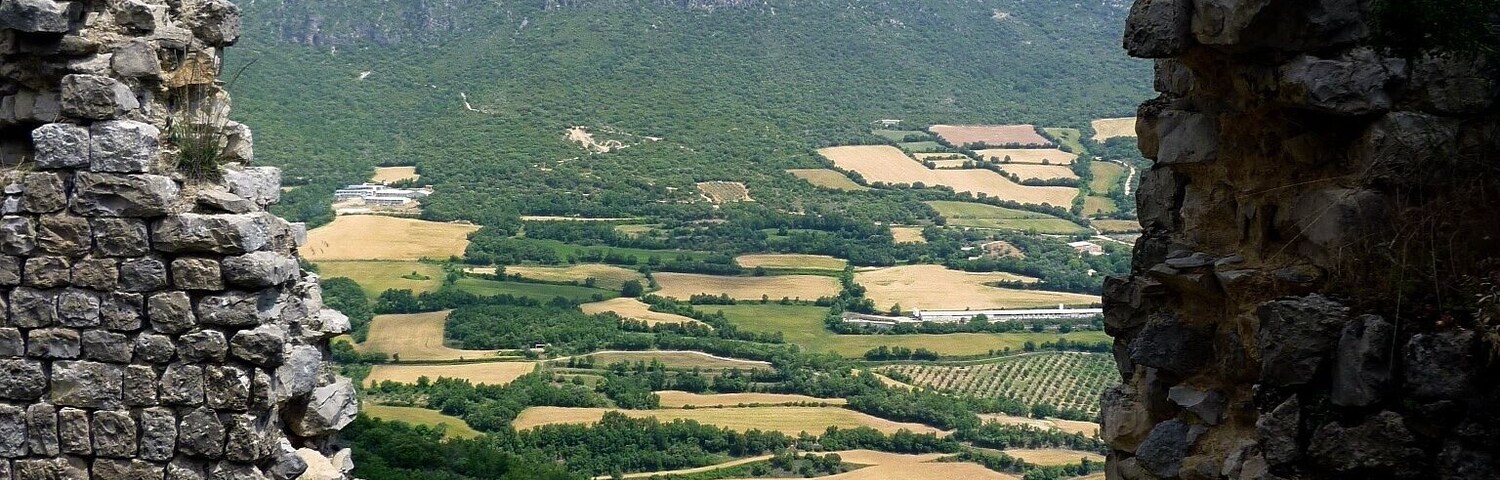Ruinas de piedra con vista a un valle y montañas.