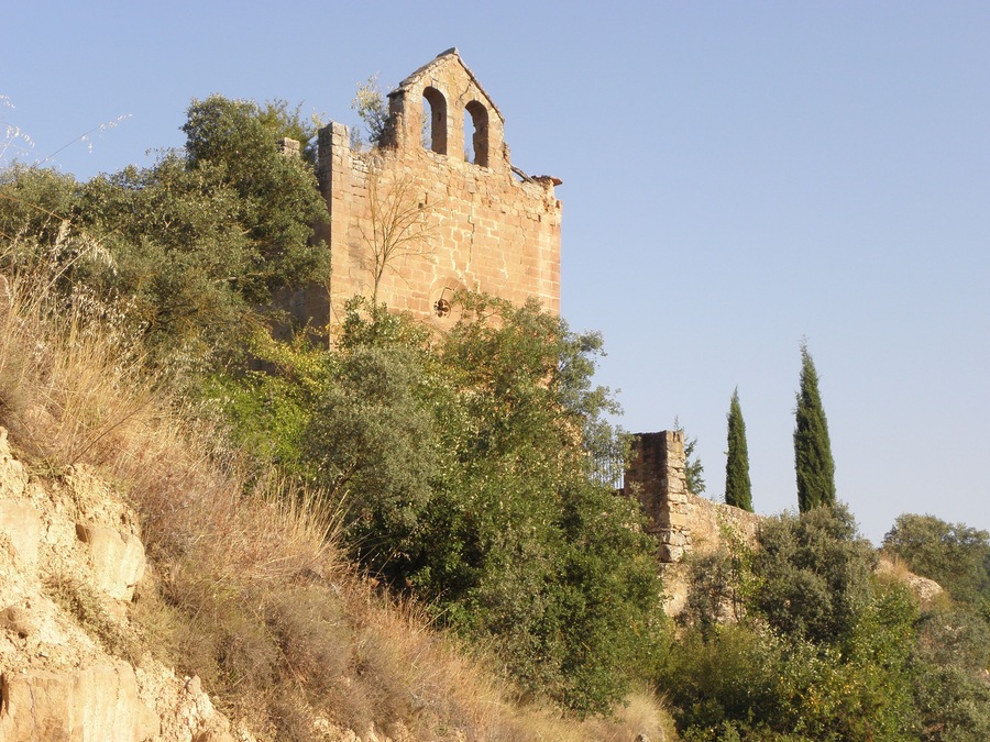 La façana principal i la tàpia del cementiri de l'església vella de Sant Jaume, al poble de Sallent (municipi de Sallent de Solsonès) vista des del camí de Sant Climenç a Sanaüja. Darrere l'església, el cementiri.