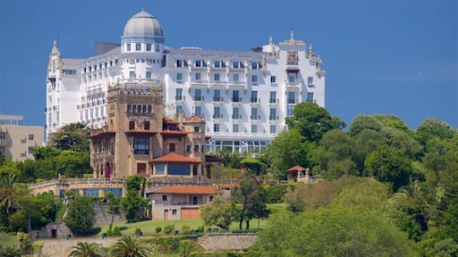 A historic building with a dome and ornate architecture, surrounded by lush greenery.
