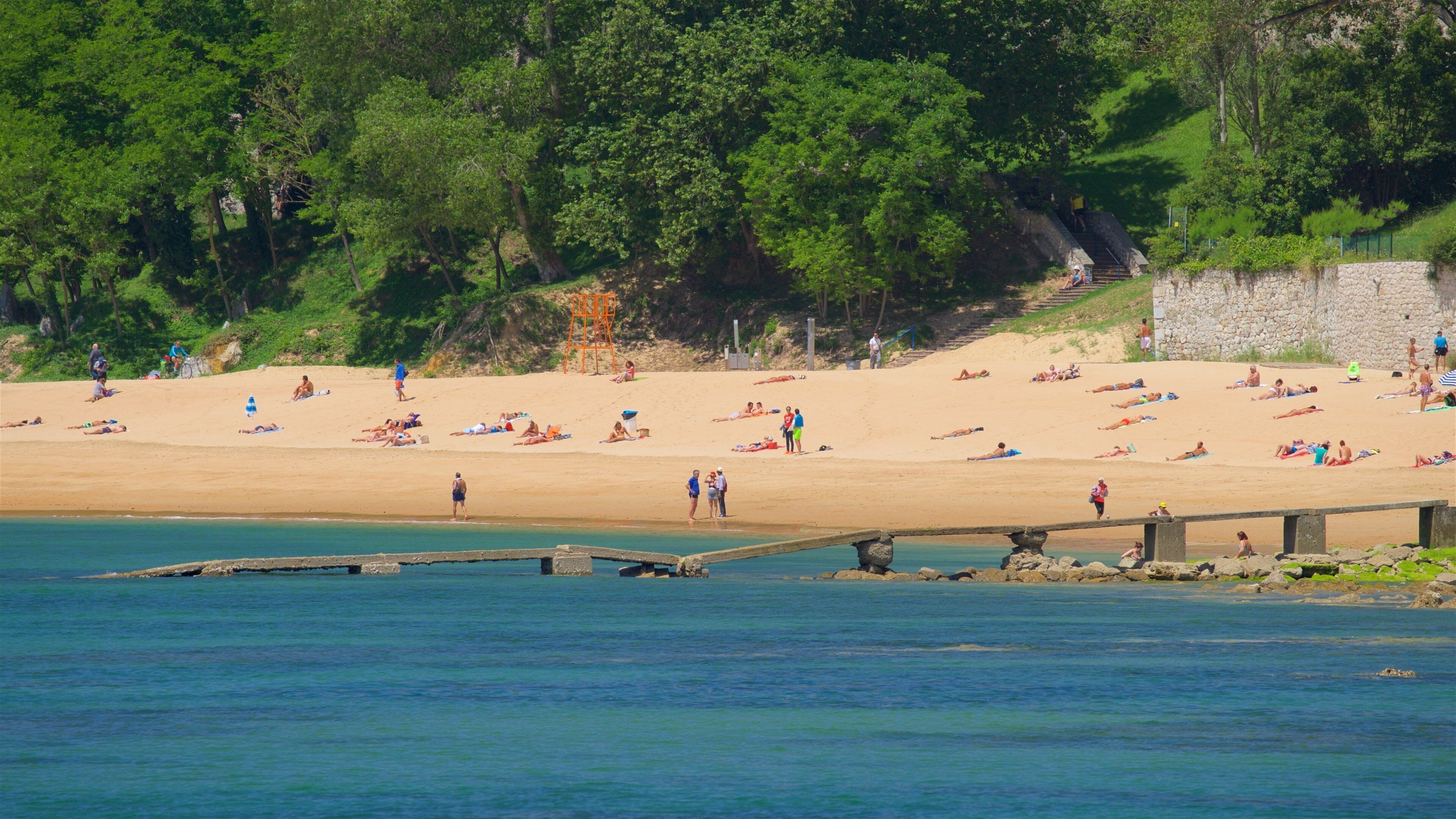 Los Peligros Beach showing a sandy beach and general coastal views as well as a large group of people