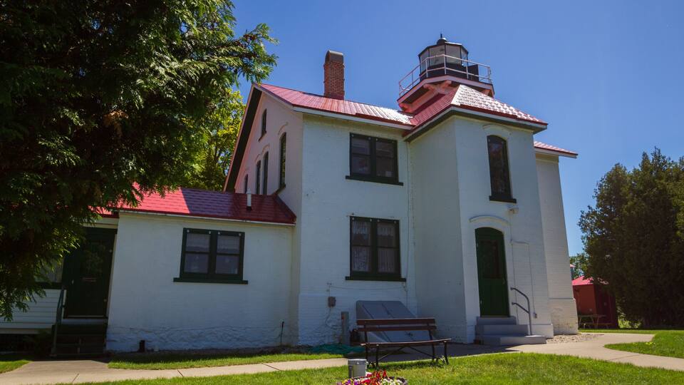 A white building with a red roof and a tower.