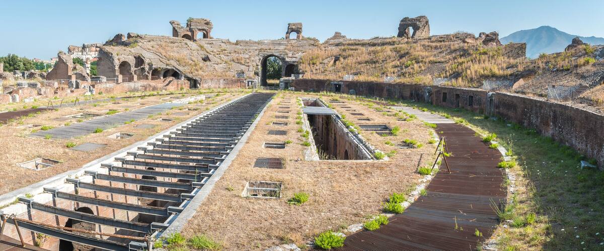 An ancient amphitheater with a central stage and surrounding seating.