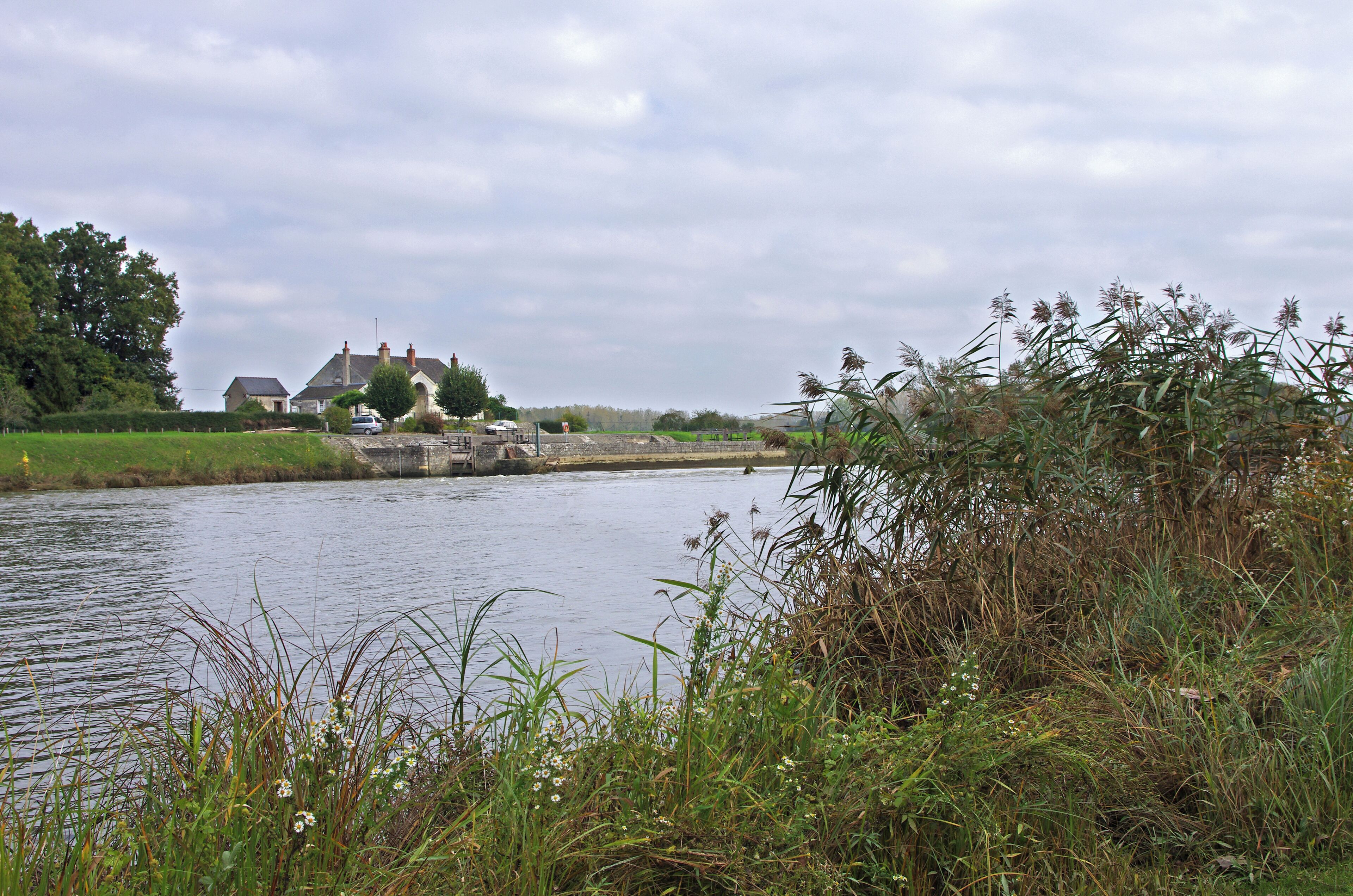 Vue d'ensemble du barrage éclusé dit de Bléré. Chaque site de barrage écluse sur le Cher canalisé est constitué d'un barrage mobile, d'un déversoir fixe pour l'écoulement des eaux surabondantes (de 20 à 45 m de long) , d'une écluse en maçonnerie, d'une maison éclusière comprenant deux logements (éclusier et barragiste) et d'annexes diverses (magasins à aiguilles notamment). Le Cher canalisé est un prolongement du canal du Berry. Il conduit de Noyers sur Cher à Saint-Avertin. Overview of the dam sluice told Bléré. Each dam site on the Cher channeled lock consists of a weir, a weir fixed water flow overabundant (20 to 45 m long), a lock masonry, house lockkeeper including two units (lock keeper and play-offs) and various annexes (including needles stores). Channeled Cher is an extension of the Berry canal. He led Noyers sur Cher Saint-Avertin.