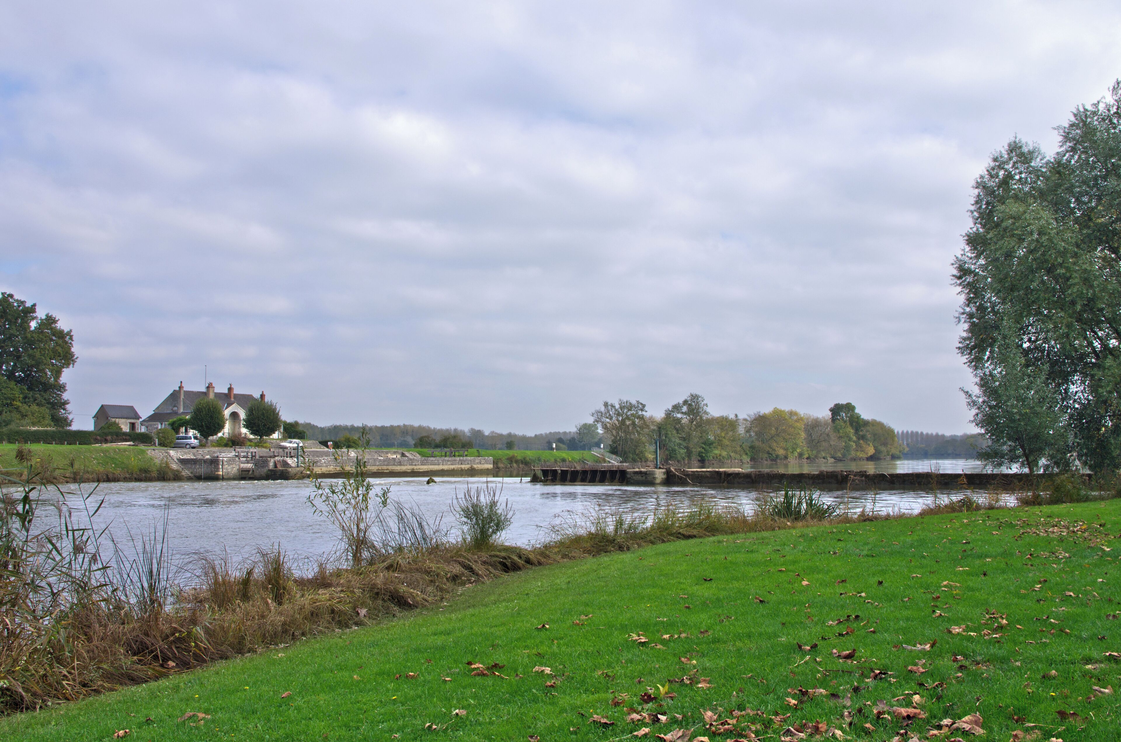 Vue d'ensemble du barrage éclusé dit de Bléré. Chaque site de barrage écluse sur le Cher canalisé est constitué d'un barrage mobile, d'un déversoir fixe pour l'écoulement des eaux surabondantes (de 20 à 45 m de long) , d'une écluse en maçonnerie, d'une maison éclusière comprenant deux logements (éclusier et barragiste) et d'annexes diverses (magasins à aiguilles notamment). Le Cher canalisé est un prolongement du canal du Berry. Il conduit de Noyers sur Cher à Saint-Avertin. Overview of the dam sluice told Bléré. Each dam site on the Cher channeled lock consists of a weir, a weir fixed water flow overabundant (20 to 45 m long), a lock masonry, house lockkeeper including two units (lock keeper and play-offs) and various annexes (including needles stores). Channeled Cher is an extension of the Berry canal. He led Noyers sur Cher Saint-Avertin.