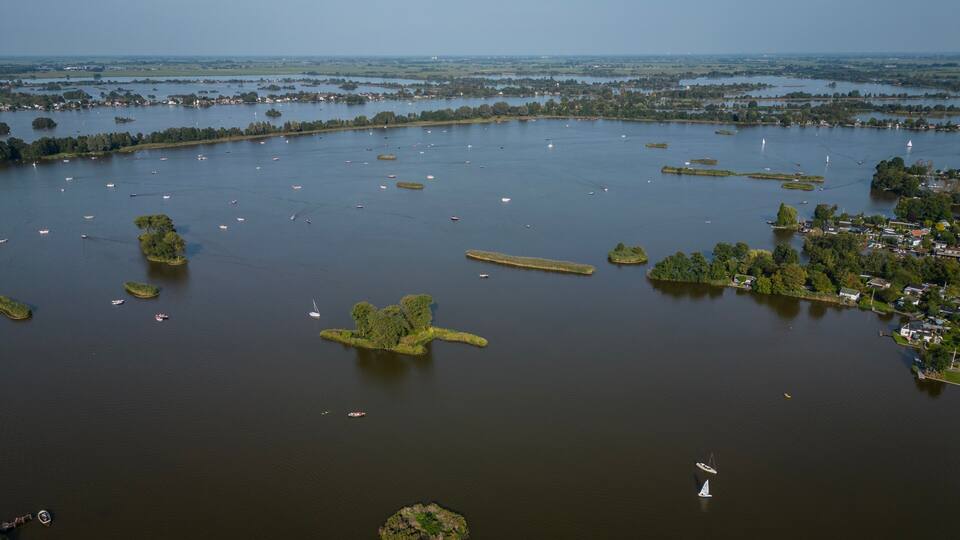 A large body of water with numerous small islands and boats.