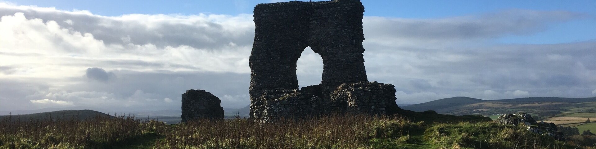 The 13th century castle ruins are the most obvious evidence of fortifications on the hill, but much older walls encircle the site! Park your car in the lay-by and take a short steep trek up the hill.